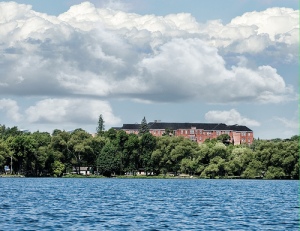 Huronia Regional Centre in the background, surrounded by lush greenery with Lake Simcoe in the foreground